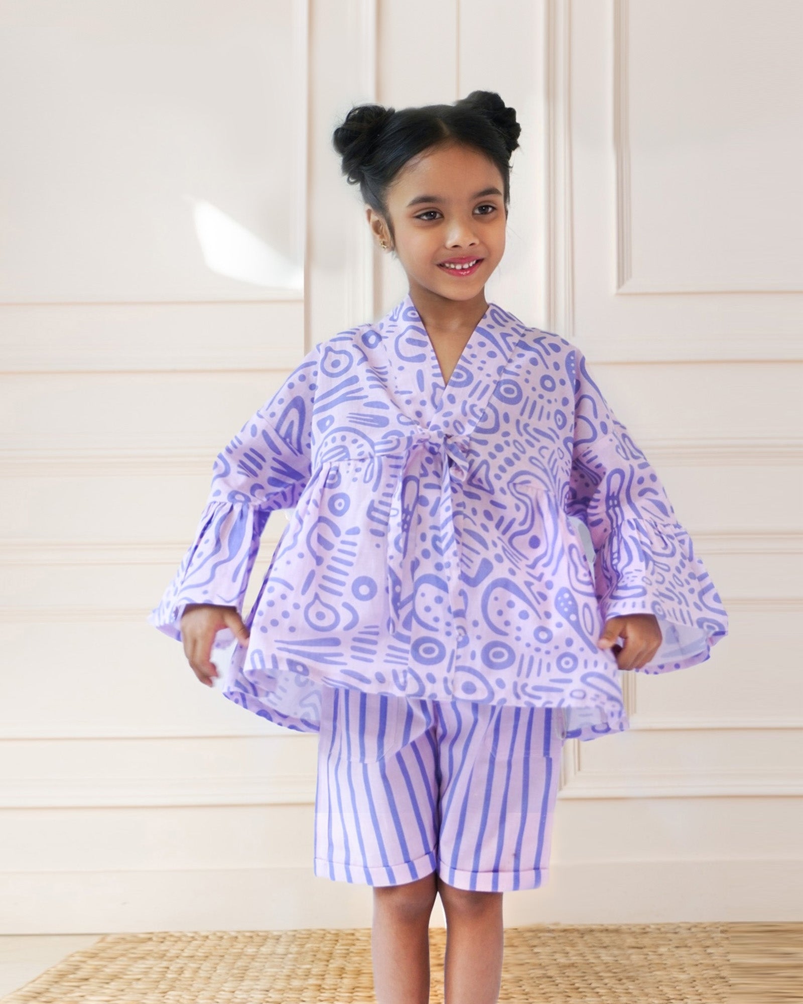Laad`s girl  wearing a lilac kimono ameba co-ord set with abstract print top and striped shorts, stylish summer kidswear from LAAD India.