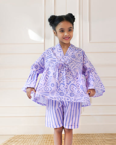 Laad`s girl  wearing a lilac kimono ameba co-ord set with abstract print top and striped shorts, stylish summer kidswear from LAAD India.