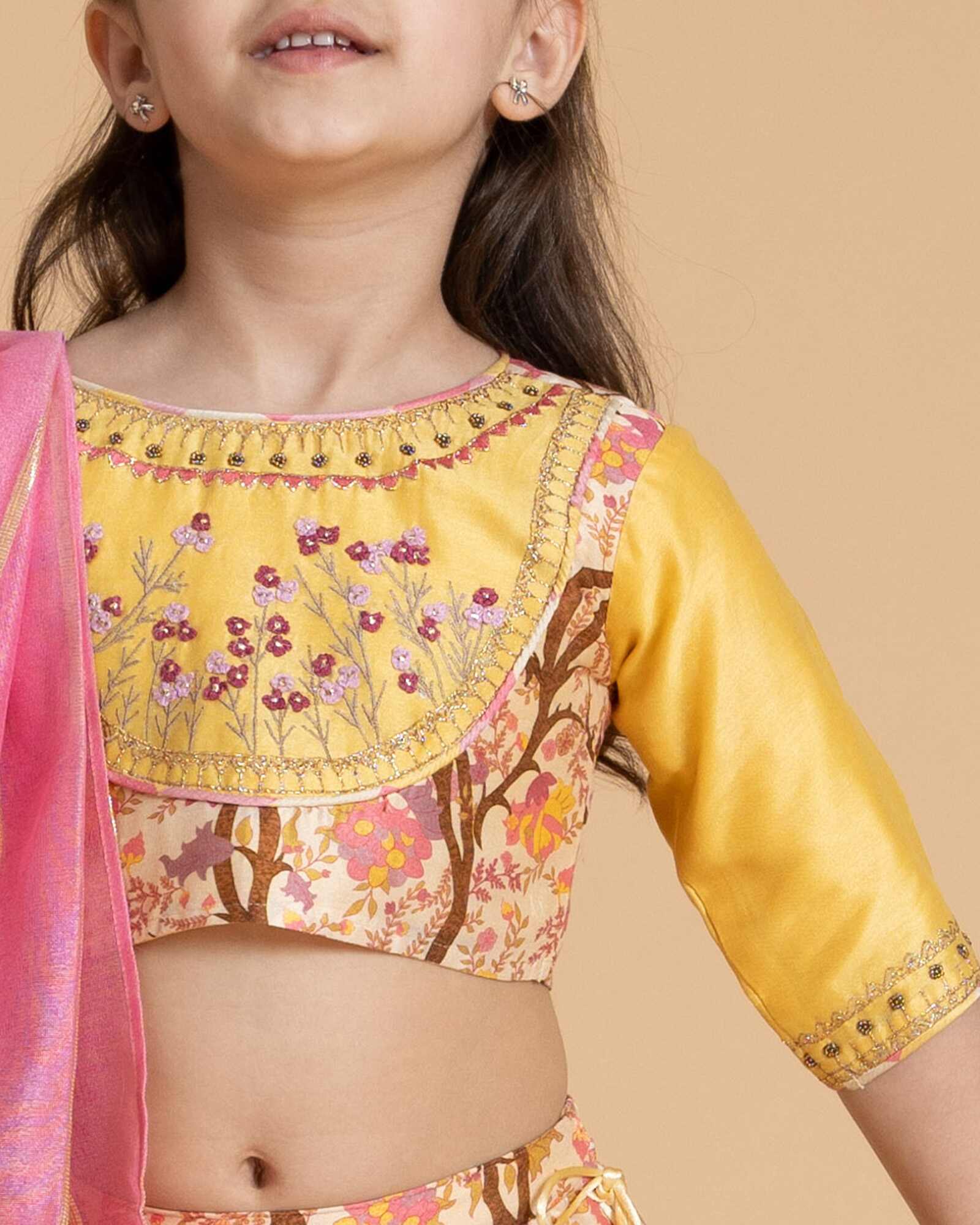 A girl in maize lehenga  a floral embroidered blouse and skirt with badla work, tassel tie-up, a perfect kids indian traditional wear by laadindia
