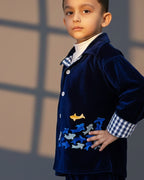 Midnite Shoal co-ord set by LAADINDIA.com, featuring a child dressed in a navy blue velvet co-ord with floating fish embroidery, front-open top with contrast check cuffs, and matching trousers for winter festive wear.