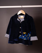 Midnite Shoal co-ord set by LAADINDIA.com, featuring a child dressed in a navy blue velvet co-ord with floating fish embroidery, front-open top with contrast check cuffs, and matching trousers for winter festive wear.