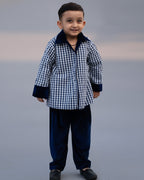 Midnite Shoal co-ord set by LAADINDIA.com, featuring a child dressed in a navy blue velvet co-ord with floating fish embroidery, front-open top with contrast check cuffs, and matching trousers for winter festive wear.