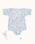 happy toddler Laad`s girl wearing a mint green kimono-style romper with pink tulip floral print .