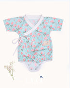 happy toddler Laad`s girl wearing a mint green kimono-style romper with pink tulip floral print .