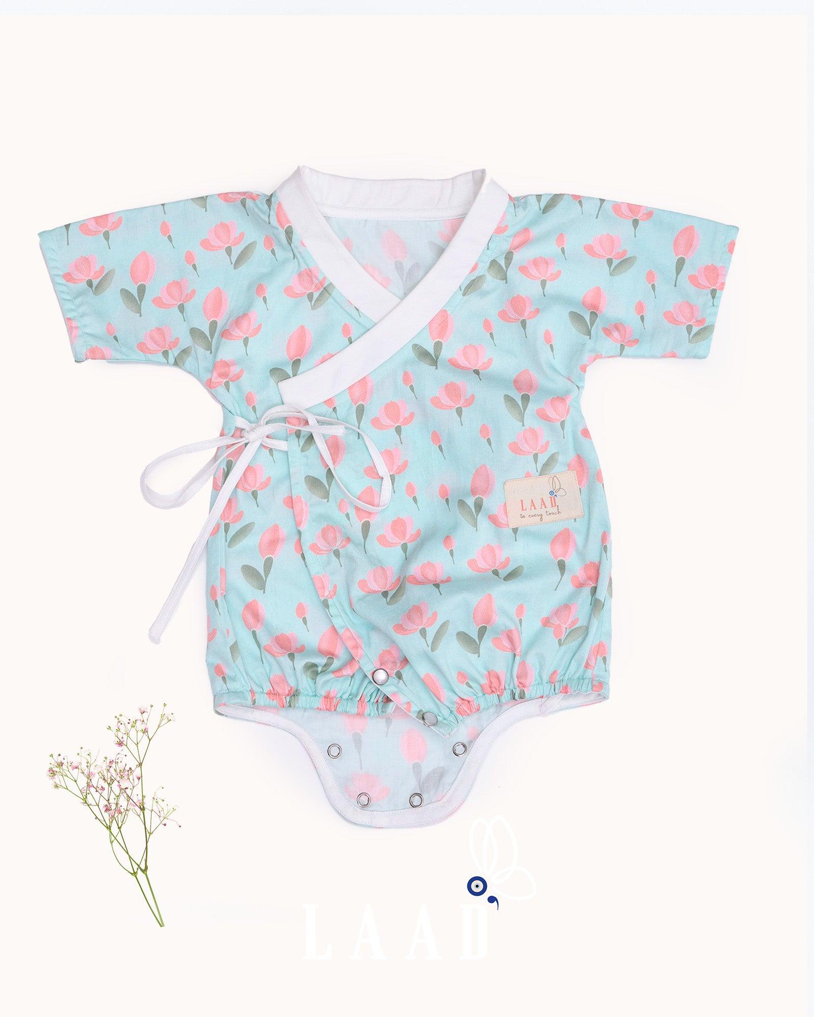 happy toddler Laad`s girl wearing a mint green kimono-style romper with pink tulip floral print .