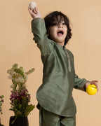 Little boy in a stylish moss green kurta set with delicate embroidery, showcasing festive elegance and comfort. Perfect ethnic wear for kids.