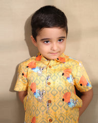 A cheerful Laad`s co-ord set in a vibrant yellow hue, featuring playful deer and geometric prints, a collared button-down shirt, and matching shorts.