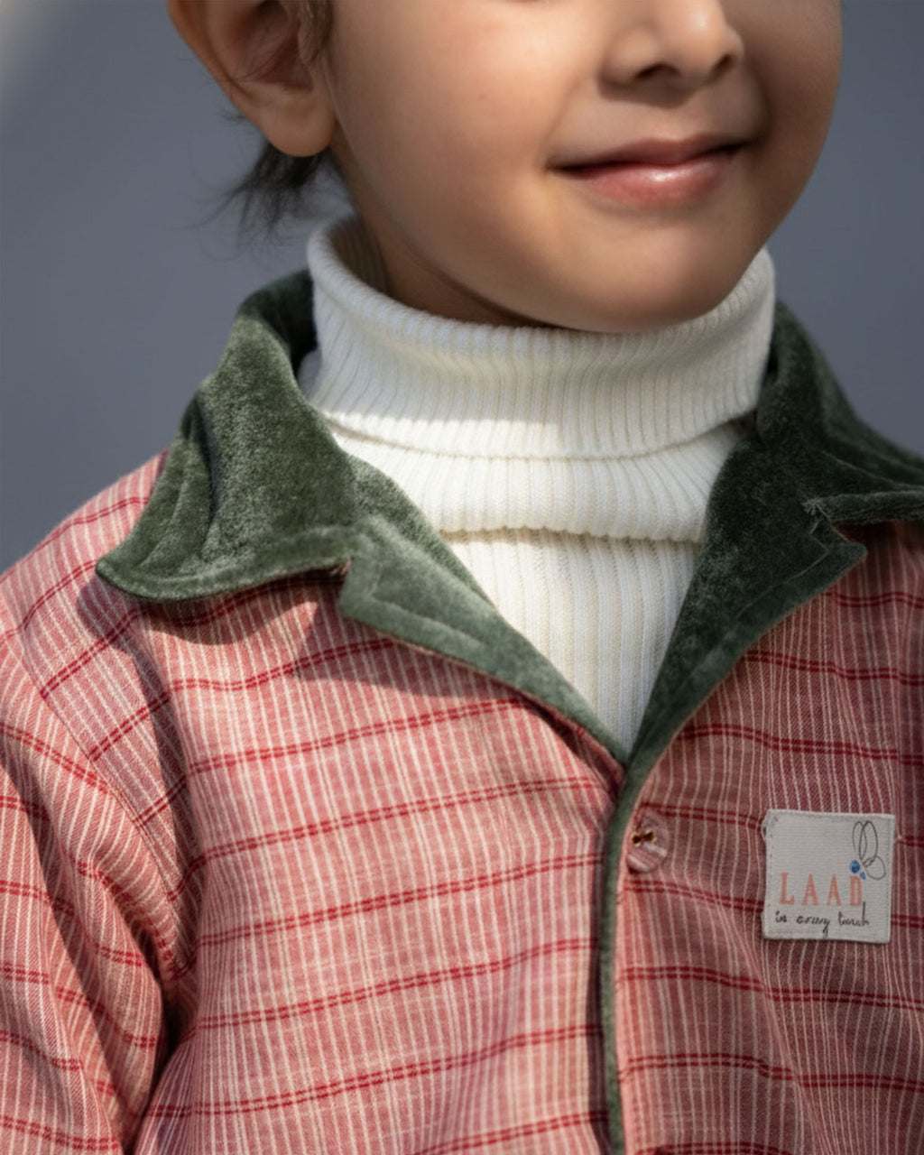 sage shoal co-ord set by LAADINDIA.com, featuring a child dressed in a navy blue velvet co-ord with floating fish embroidery, front-open top with contrast check cuffs, and matching trousers for winter festive wear.