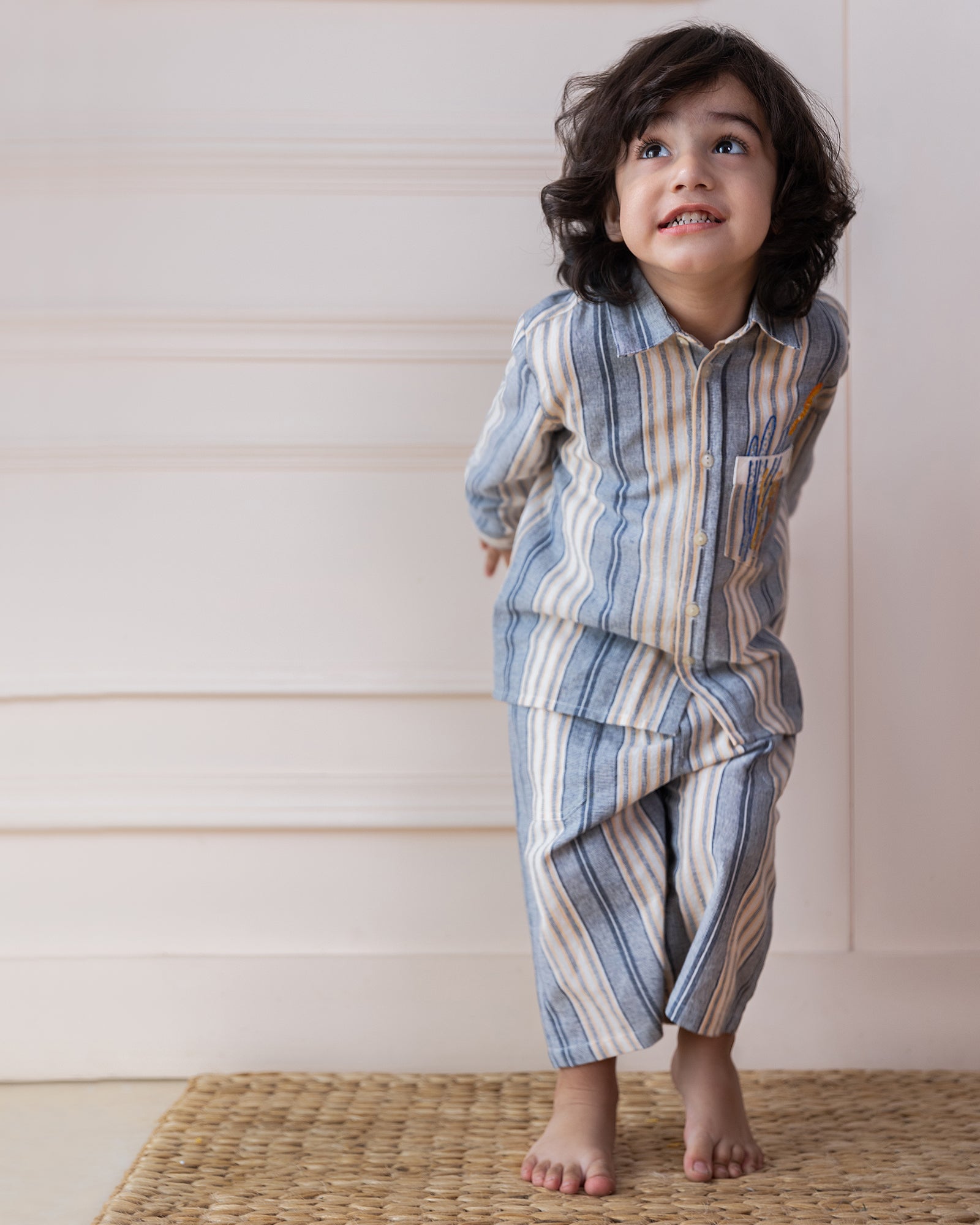 laad`s Kids' striped co-ord set with a long-sleeve shirt and shorts, featuring soft beige and gray tones. Embroidered seahorse detail adds a playful touch. Lightweight, breathable fabric for all-day comfort.