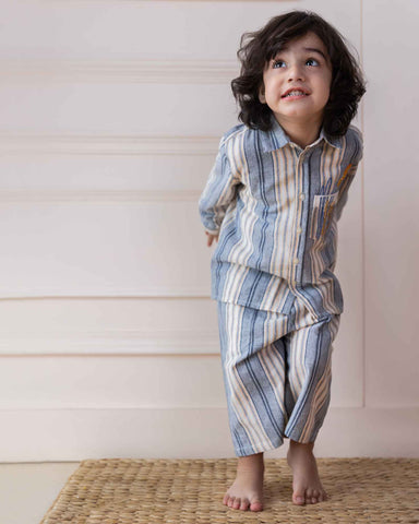 laad`s Kids' striped co-ord set with a long-sleeve shirt and shorts, featuring soft beige and gray tones. Embroidered seahorse detail adds a playful touch. Lightweight, breathable fabric for all-day comfort.