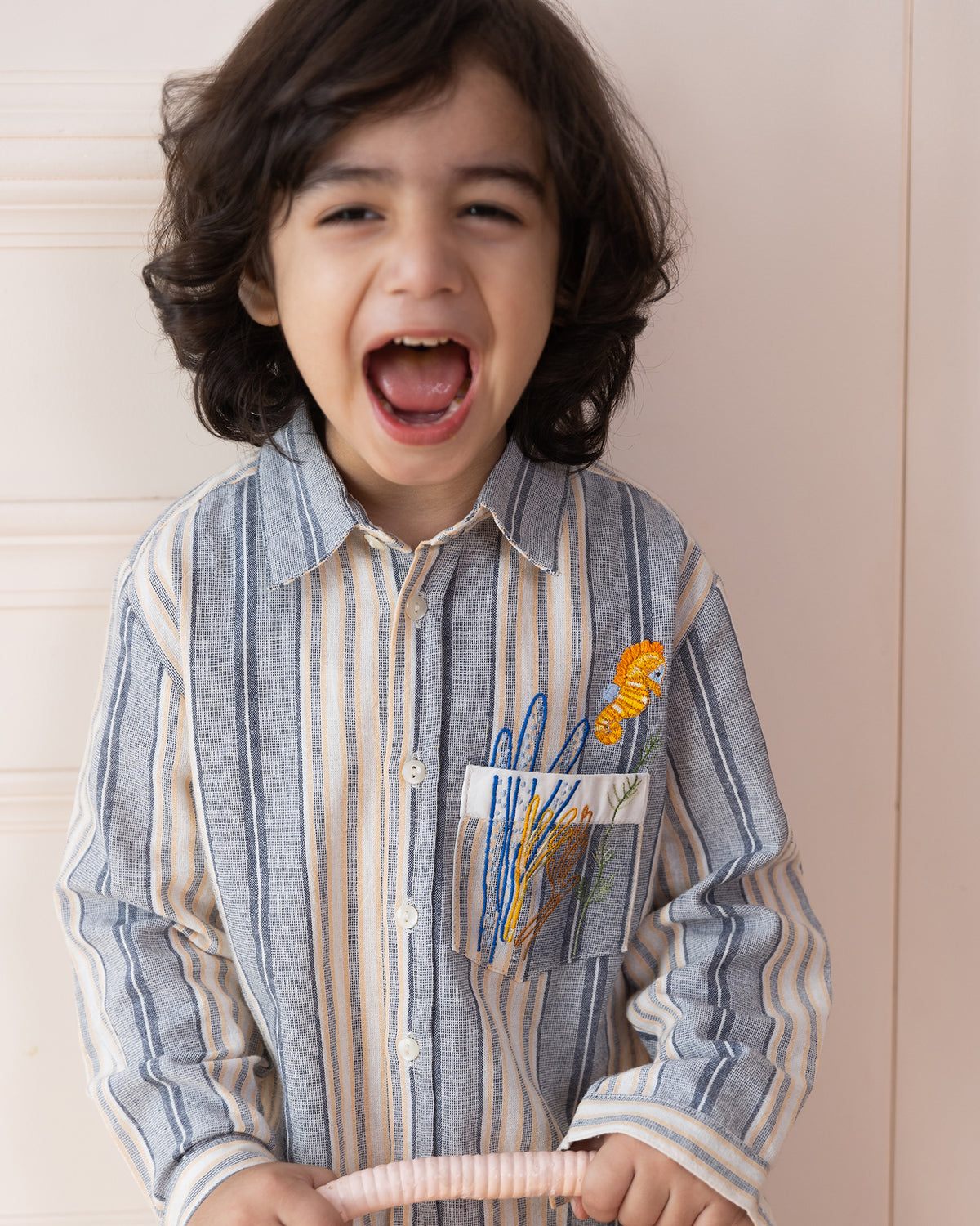 laad`s Kids' striped co-ord set with a long-sleeve shirt and shorts, featuring soft beige and gray tones. Embroidered seahorse detail adds a playful touch. Lightweight, breathable fabric for all-day comfort.