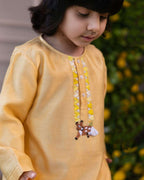 Elegant yellow kurta pyjama set for kids by Laad India, featuring delicate beadwork, intricate hand embroidery of a bambi, and a soft cotton lining for ultimate comfort. Perfect ethnic wear for festive occasions and celebrations