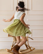 LAAD`S kid in Titalee moss green dress by Laad India, featuring delicate floral embroidery, an eyelet lace bodice, and a gingham checkered dress. A perfect blend of vintage elegance and modern comfort for your little one
