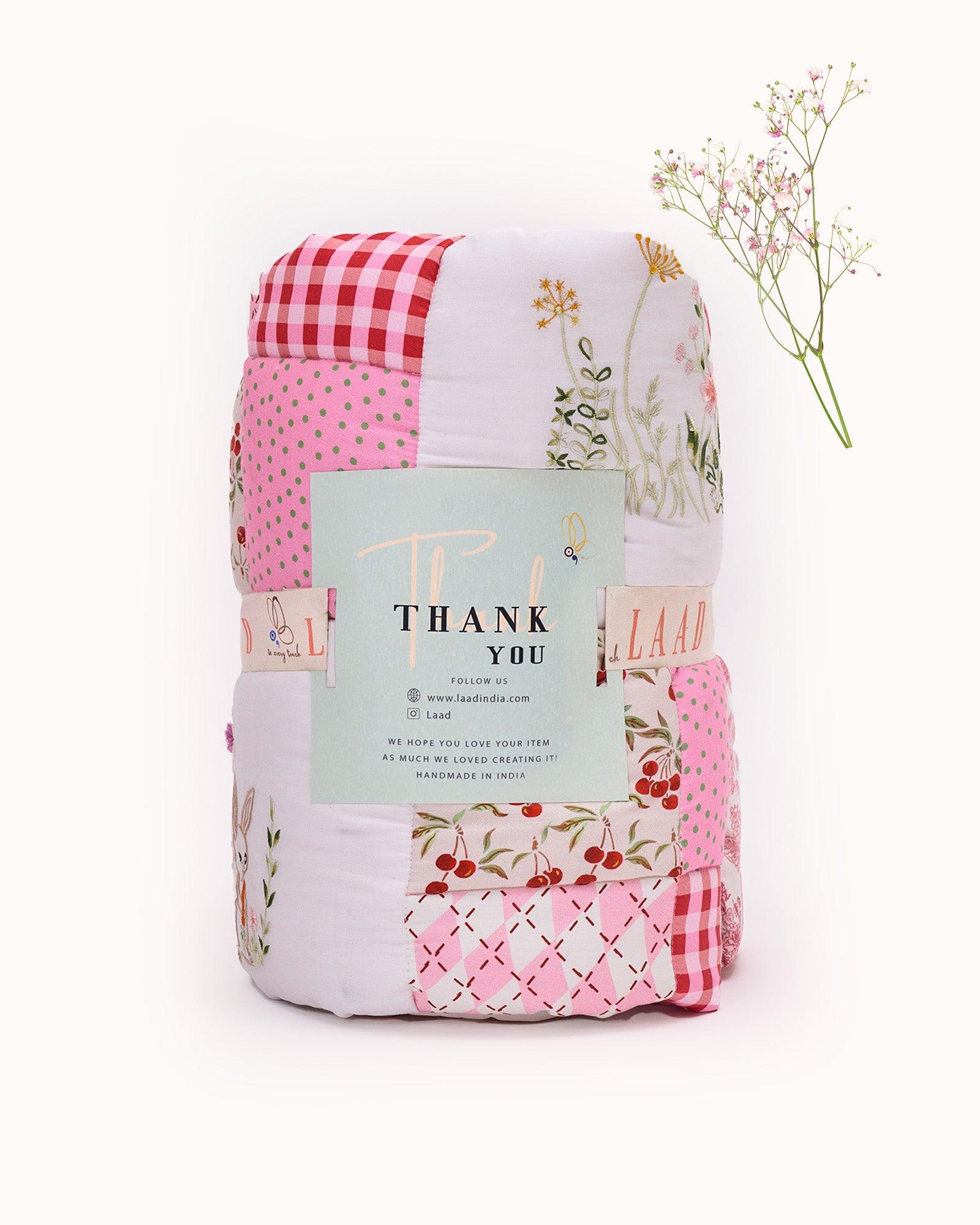 laad`s girl wearing white Rabit quilt features playful rabbits & vibrant scarlet for a touch of magic. Soft cotton & cozy fiber filling for ultimate comfort. 