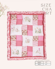 laad`s girl wearing white Rabit quilt features playful rabbits & vibrant scarlet for a touch of magic. Soft cotton & cozy fiber filling for ultimate comfort. 