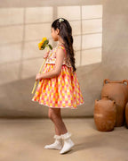 Girl wearing the Zinnia party wear DRESS featuring a vibrant checkered kurta with embroidered and printed jacket detailing , perfect for festive occasions and birthday party